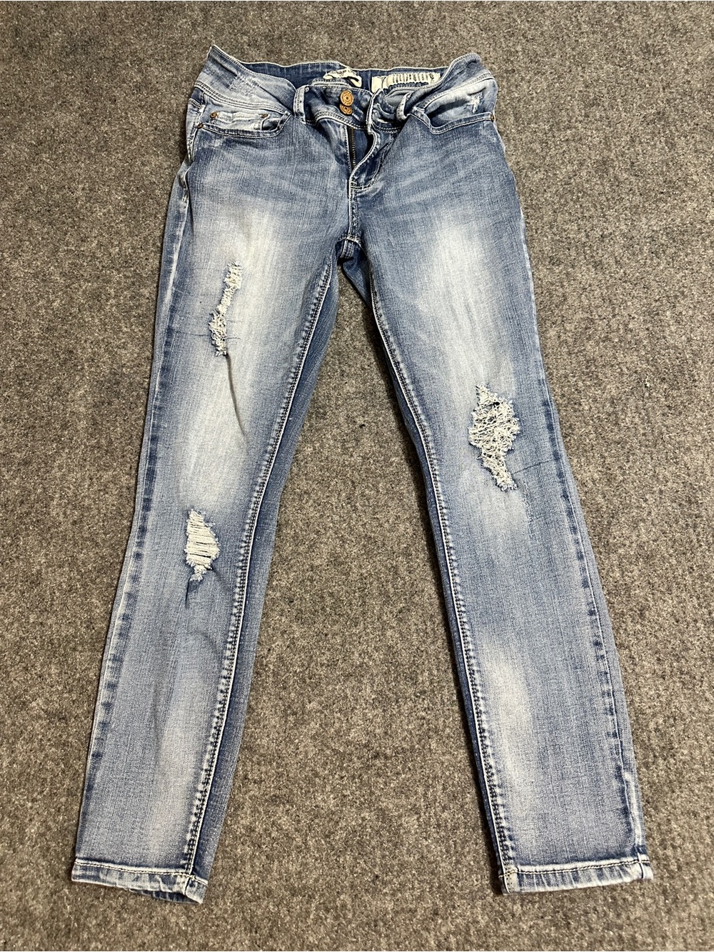 These appear to be light-to-medium wash distressed skinny denim jeans